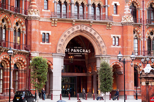 London, United Kingdom - July 21, 2011: St. Pancras Hotel in London. Some people are outside of hotel. Hotel is next to train station.