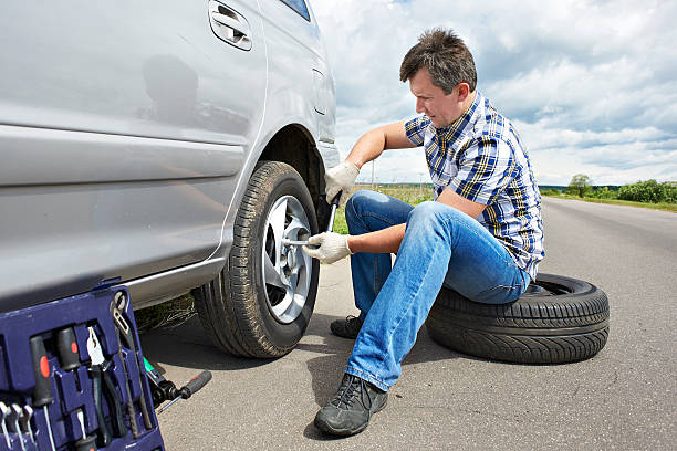 istock Man changing spare tire of car 543328132