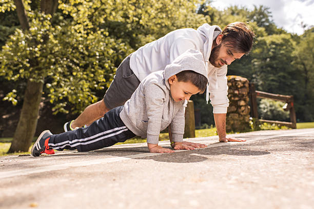 istock Father and son exercising push-ups in the park. 543329494