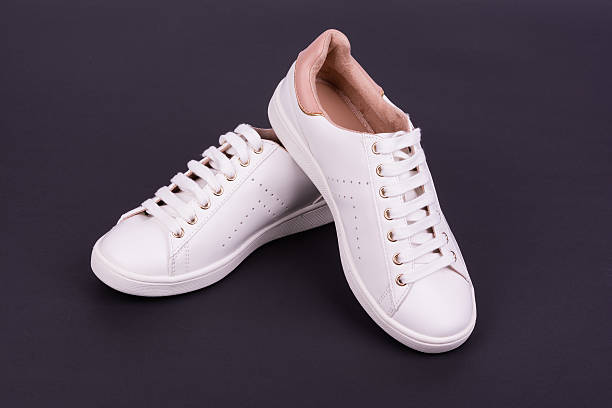 istock Women's white sport shoes on dark background 543331044