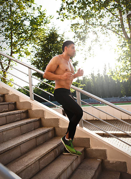 istock athletic sport runner man running up stairs in urban training 543332434