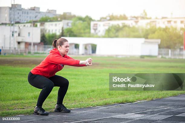 Photo libre de droit de Femme En Vêtements De Faire Des Squats En Plein Air banque d'images et plus d'images libres de droit de Accroupi