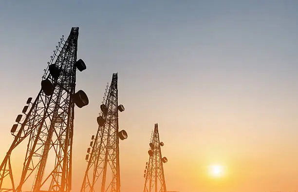 Photo of Silhouette, telecommunication towers with TV antennas, satellite dish in sunset