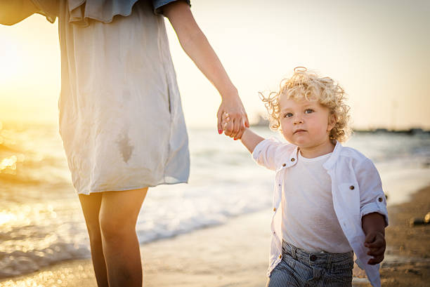 istock Mother and son walking at the beach 543337552