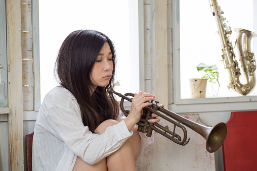 Beautiful Young Japanese Woman is practicing trumpet