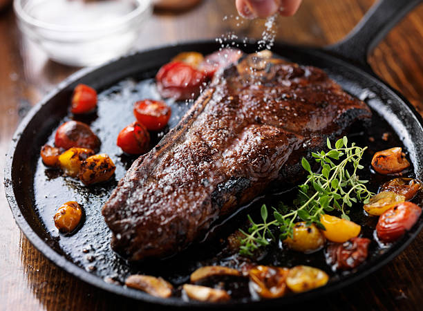 sprinking sale marino su una bistecca striscia ny - strip steak immagine foto e immagini stock