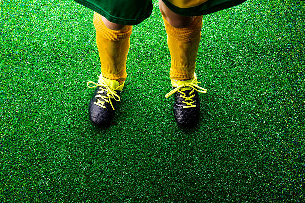istock Unrecognizable little football player against green grass, studi 543344720