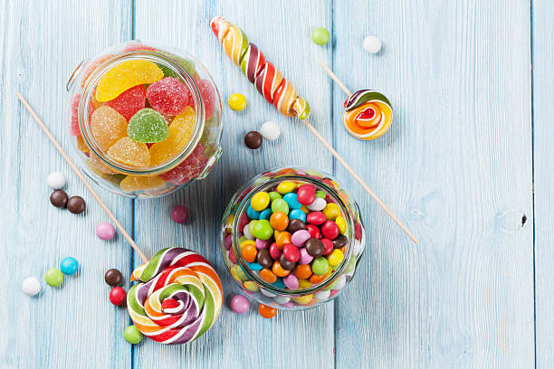красочные конфеты на деревянном столе - gelatin dessert multi colored vibrant color celebration стоковые фото и изображения