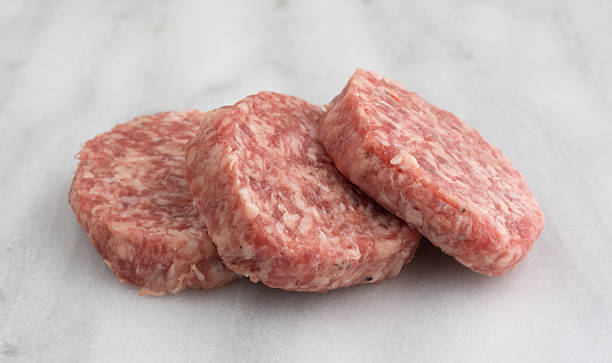 istock Fresh sausage patties on a marble cutting board 543345244