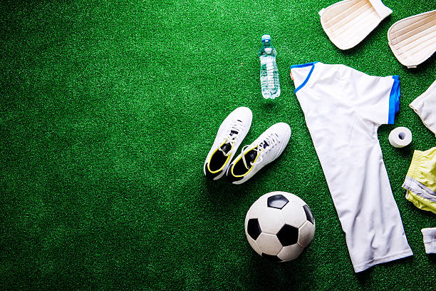 istock Soccer ball,cleats and various football stuff against artificial 543345310