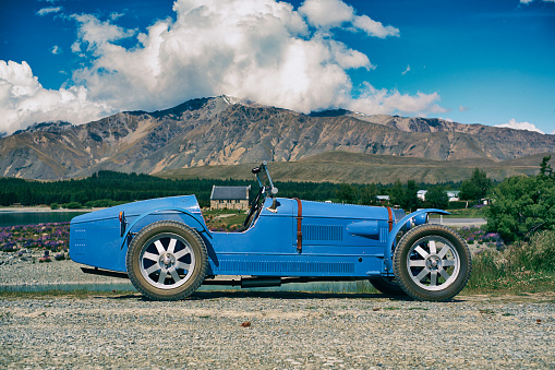 Takepo, Canterbury, New Zealand - December 9, 2012: Summer sunshine falls on an Acorn, a replica of a 1927 Type 35 Bugatti. In the background we see the famous Church of the Good Shepherd sitting on the shores of Lake Tekapo, on New Zealand's South Island.