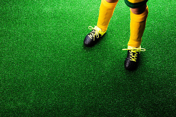 istock Unrecognizable little football player against green grass, studi 543346134