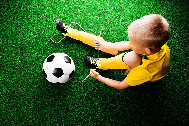 riconoscibile piccolo giocatore di calcio in erba verde, studi - soccer child indoors little boys foto e immagini stock