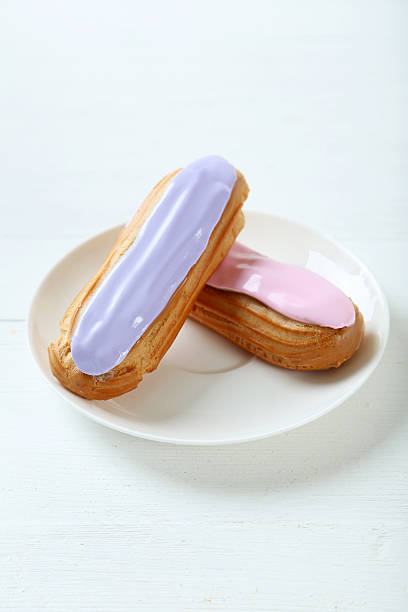 istock Eclairs with glaze on a white wooden table 543347742