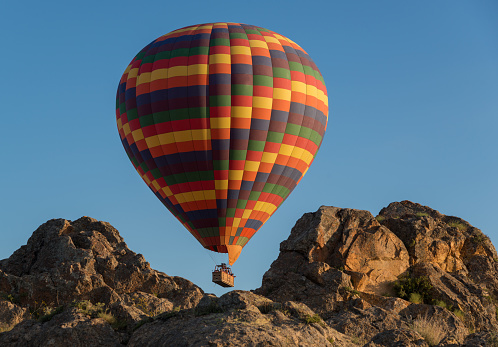 Multicoloured balloon over Cappadocia rocks.