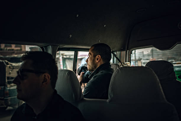 Reporters on a mission Photo of a news reporters sitting in a van, waiting for a story to capture reportage photos stock pictures, royalty-free photos & images
