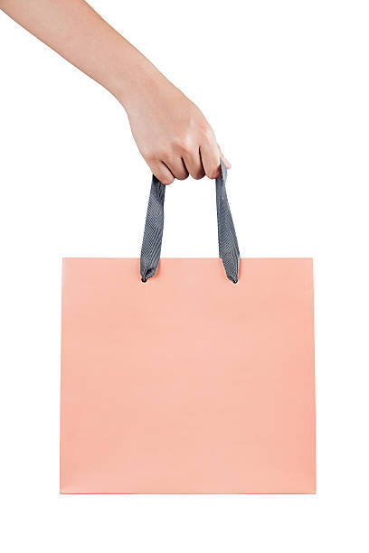 mujer (mujer) mano sostenga una bolsa de compras rosa (bolsa de papel) - bag white paper bag paper fotografías e imágenes de stock