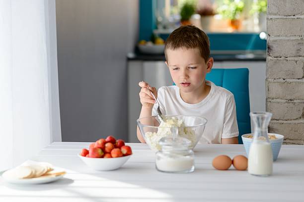 istock Child mixing white cottage cheese in a bowl 543352538