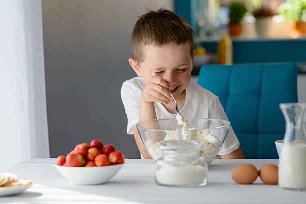 istock Child mixing white cottage cheese in a bowl 543352666