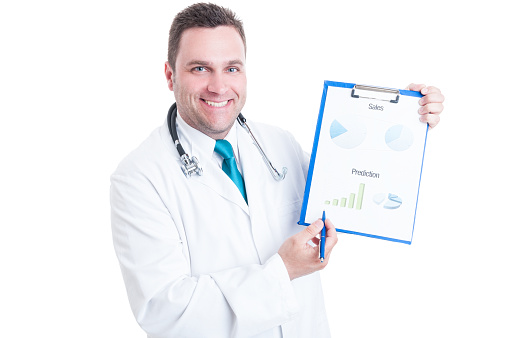 Male medic or doctor smiling and showing predictions statistics on clipboard isolated on white background