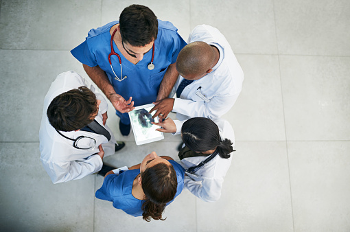 Shot of a diverse team of doctors viewing an x-ray on a digital tablet