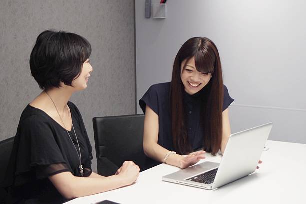 Japanese businesswomen discussing Japanese women talking at the company talking two people business talk business stock pictures, royalty-free photos & images