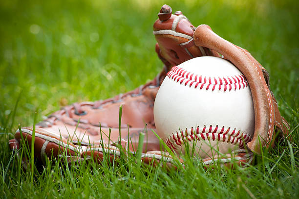 istock Baseball ball and glove on green grass 543355126