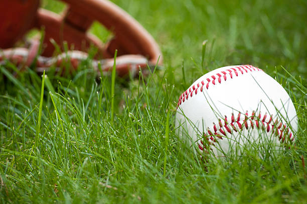 istock Baseball ball and glove on green grass 543355134
