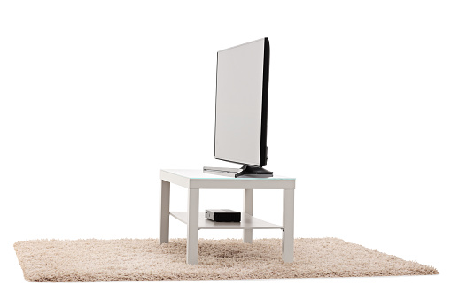 Studio shot of a big flat screen TV white table isolated on white background