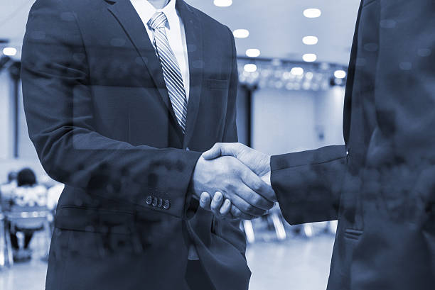 istock double exposure  business handshake and blur seminar conference 543355700