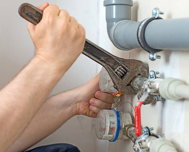 istock Male plumber fixing water meter with adjustable wrench. 543356840