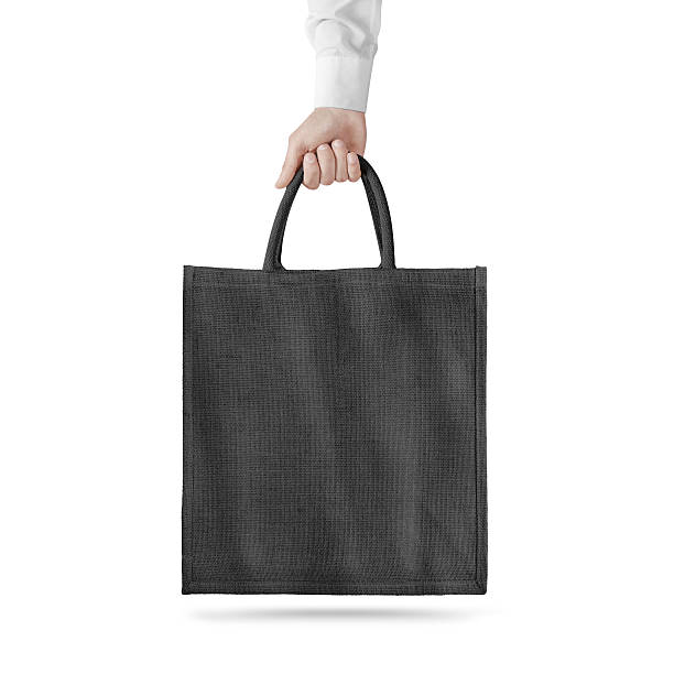istock Blank black cotton eco bag design mockup isolated, holding hand 543358582