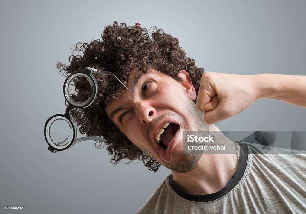 Funny man is getting punch in face with fist. Human Face Stock Photo