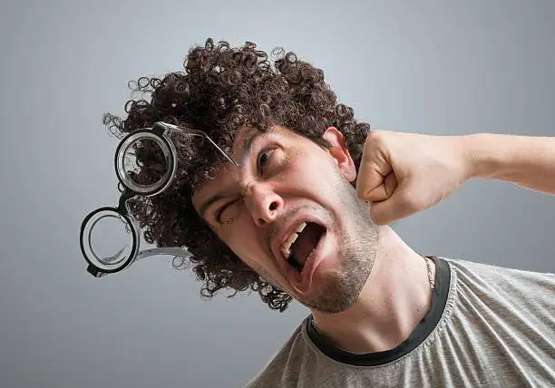 Photo of Funny man is getting punch in face with fist.