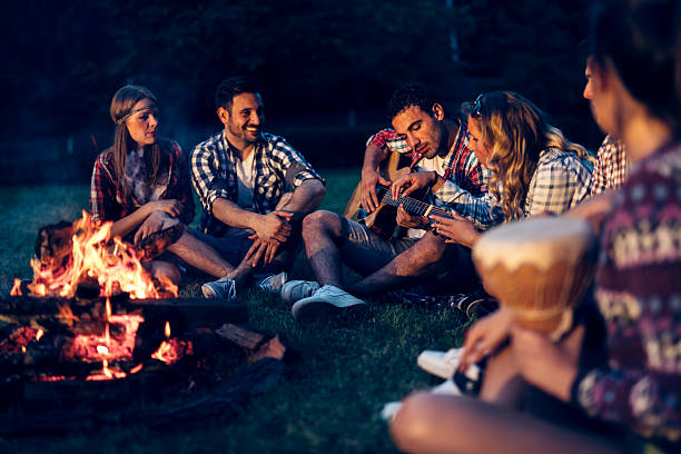 istock Friends enjoying music near campfire 543360882