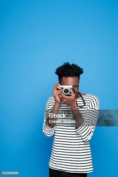 Afro American Young Man Photographing Stock Photo - Download Image Now - Colored Background, Photographer, Hobbies