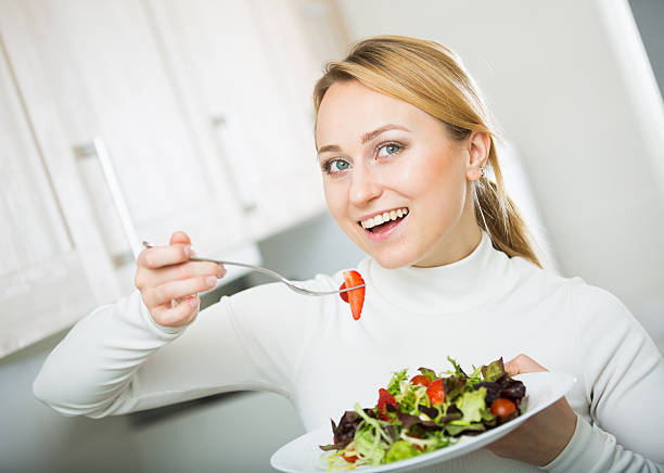 istock Cheerful blond girl eating salad 543361498