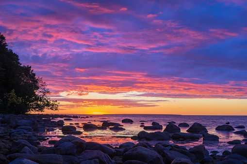 Vivid sunset over stony coast of Baltic sea, fiery cloudscape