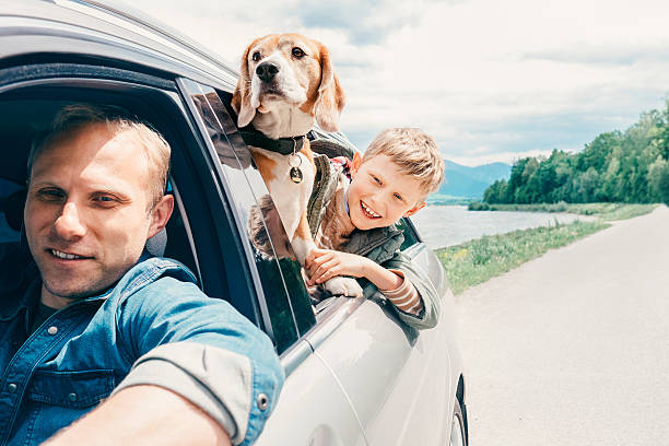 istock Father with son and dog look from the car window 543447160