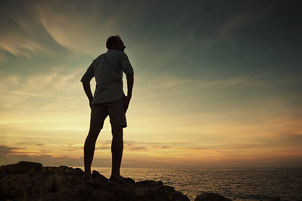 istock Man on the sea coast look on the sunset 543447316