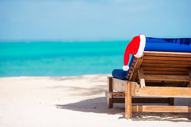 istock Sun lounger with Santa hat at beautiful tropical beach 543449326