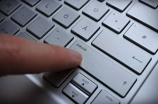 Photo of Pushing the break-button on a german silver QWERTZ keybord.