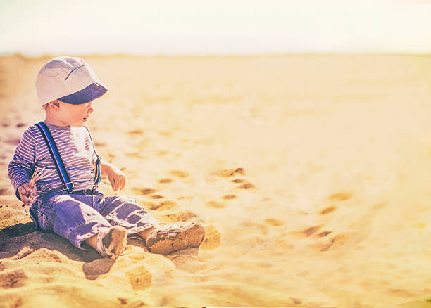 retro style. child playing in the sand looking to the right. copy space for your text