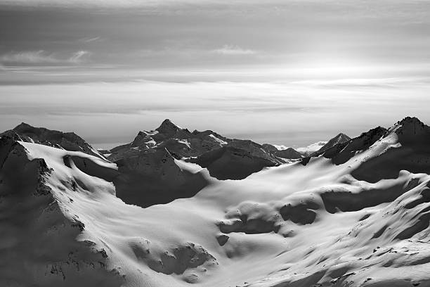 istock Black and white snowy mountains in evening 543460250