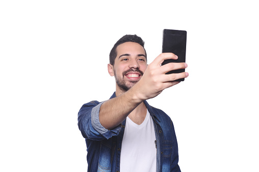 Portrait of attractive young man taking a selfie with his smartphone. Isolated white background.