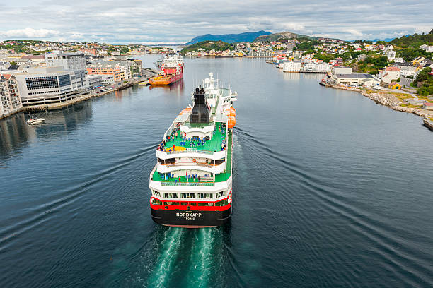 Kristiansund, Norway - August 16, 2014: Hurtigruten cruise ship is entering Kristiansund in Norway. Some passengers are on deck. Photo is made from a bridge.