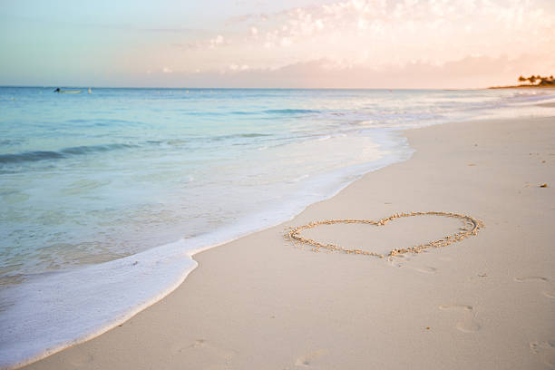 istock Heart drawn in the sand. Beach background. Top view 543468592