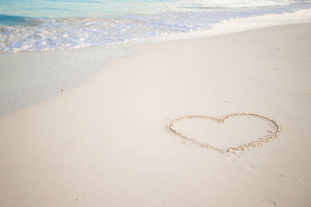 istock Heart drawn in the sand. Beach background. Top view 543468620