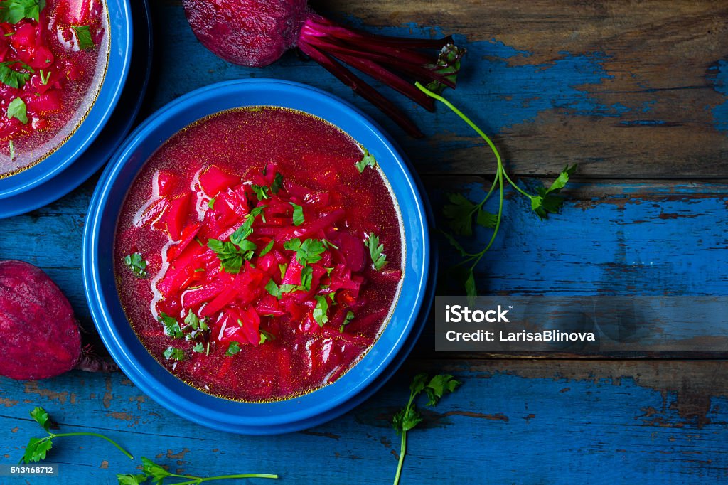 Borsh. Russian and Ucrainian traditional vegetarian red soup. Top view Russian and Ucrainian traditional vegetarian red soup - borsch in blue plates on wooden background. Top view Borscht Stock Photo