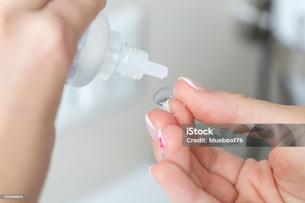 Contact lens, case and bottle of solution close-up Contact lens on finger and bottle of solution close-up Contact Lens Stock Photo